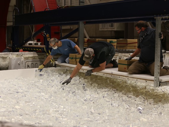 Engineers at the Richard F. Caris Mirror Lab hand-load chunks of glass into the mold. Almost 20 tons of glass are added this way before the lid will be closed and the furnace fired up to melt the glass.